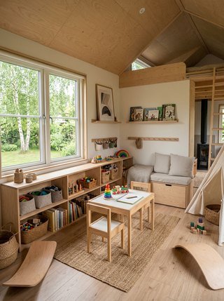 Children's play area within a Scandinavian tiny house, filled with soft light from a low-set window